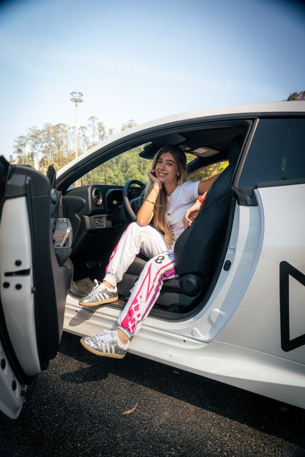 Valentina Piaz sitting in the open door of a white sports car